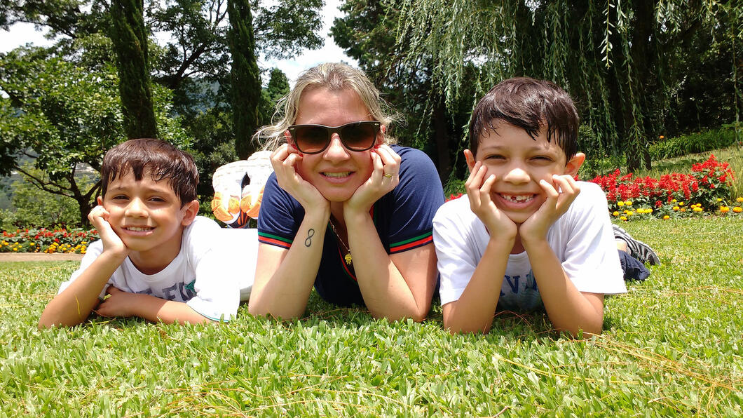 vrouw met twee kinderen liggend op een gazon