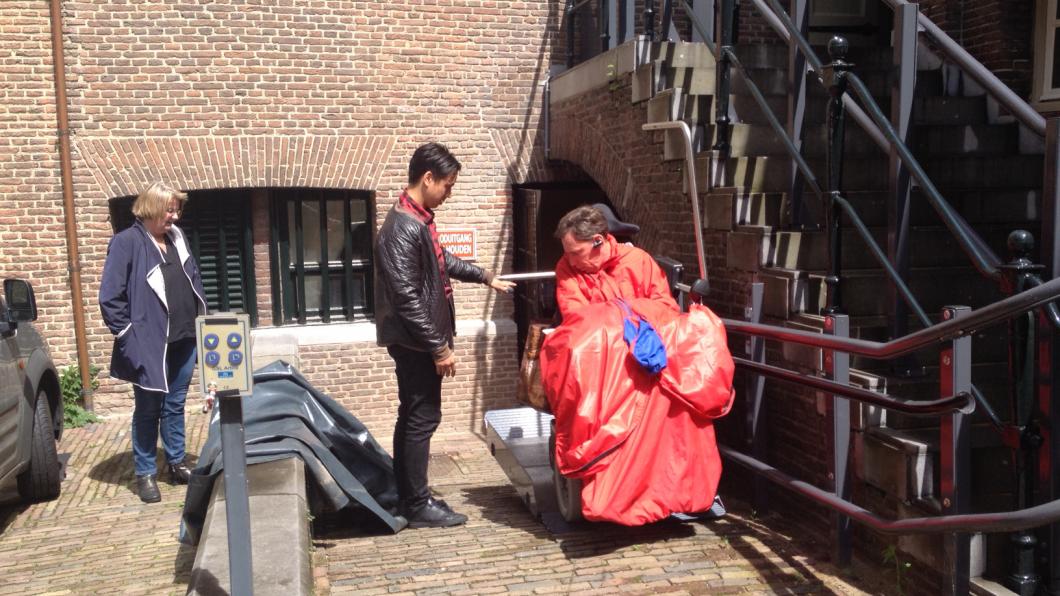 David rijdt het liftje op, roos staat erbij , aan de achterkant van het stadhuis 15 juni 2016.jpg
