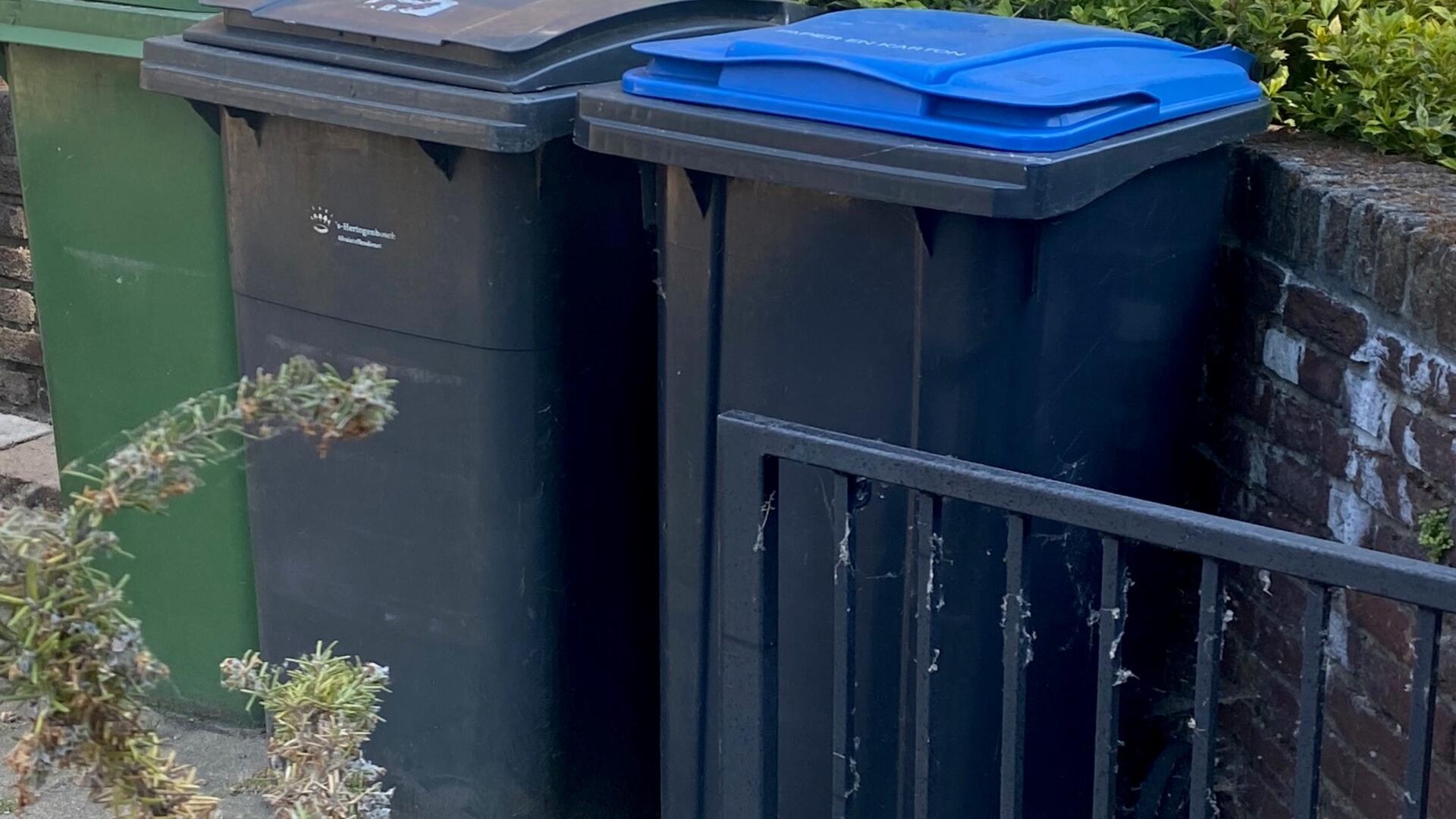 tuin met drie verschillende gekleurde afvalcontainers